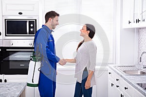 Smiling Woman Showing Thumbs Up Sign With Pest Control Worker