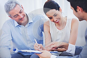 Smiling woman sign on a contrat with her partnership on sofa