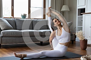 Smiling woman sit on mat perform Compass or Sundial asana