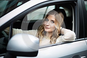 Smiling woman sitting in car on a driver`s seat