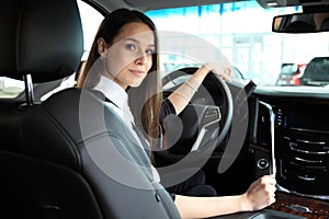 Smiling woman sitting in a car and looking back. Toned image