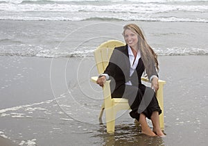 Smiling woman sitting in chair in ocean