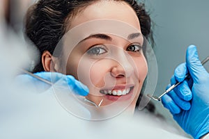 Smiling woman sitting in dentist chair ready for a dental check-up. Close up view