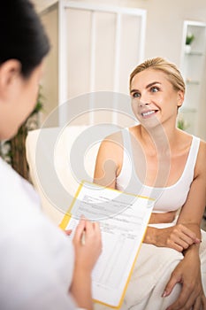 Smiling woman sitting in front of her beutician.