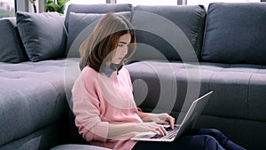 Smiling woman sitting on sofa relaxing while browsing online shopping website.