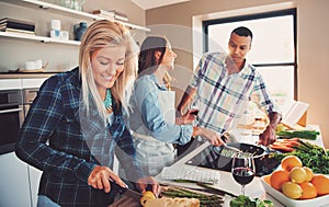 Smiling woman slicing ingredients for meal