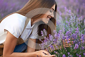 Smiling woman smelling scent in lavender field.