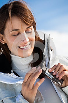 Smiling Woman on the snow applying a protective cream