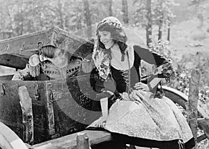 Smiling woman with soldier emerging from trunk