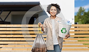 smiling woman sorting plastic and paper waste