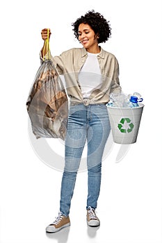 smiling woman sorting plastic and paper waste