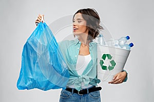 Smiling woman sorting plastic waste and trash bag