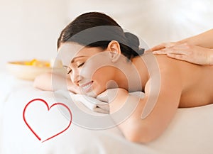 Smiling woman in spa salon getting massage