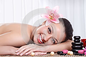 Smiling woman in spa salon, stone massage