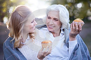 Smiling woman spending picnic with retired mother in the park