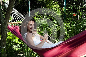 Smiling woman with spikelet in hammock. concept of summer rest and vacation. happy girl hold spikelet. girl in dress relax in