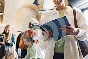 smiling woman standing with copybooks near