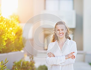 Smiling woman standing in front of house building