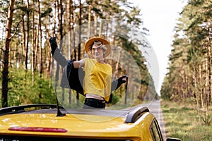 Smiling Woman Standing out of Yellow Car Sunroof