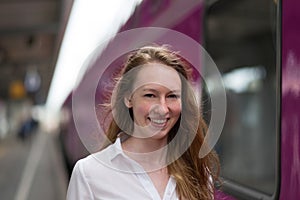 Smiling woman standing on a train station platform