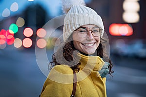 Smiling woman on street during winter dusk