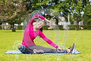 Smiling woman stretching leg on mat outdoors