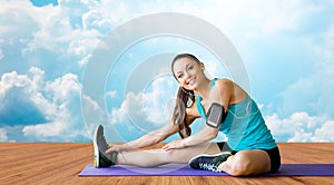 Smiling woman stretching leg on mat over clouds