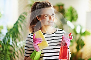 Smiling woman in striped shirt in sunny day housecleaning photo