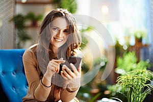 Smiling woman in sunny day sending text message using phone