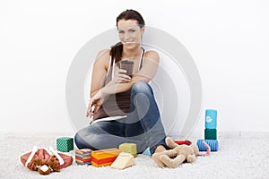 Smiling woman surrounded by baby toys