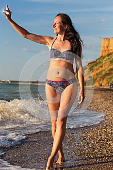 Smiling woman in swimsuit with polished sea glass