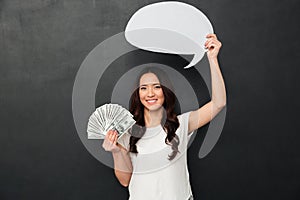Smiling woman in t-shirt holding money and blank speech bubble