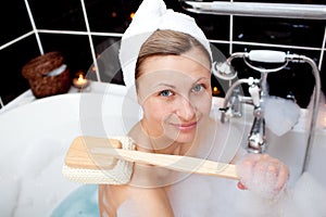 Smiling woman taking in a bubble bath
