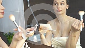 Smiling Woman Taking Mobile Selfie Photo On Phone At Bathroom Mirror.