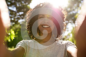 Smiling woman taking a selfie outside on a sunny day