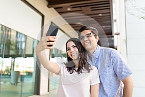 Smiling Woman Taking Selfportrait With A Date