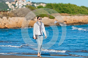 Smiling woman taking a stroll on the beach