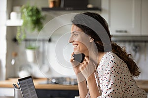 Smiling woman talk on cellphone gadget at home