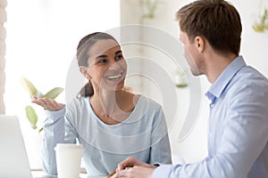 Smiling woman talking with colleague during break at workplace