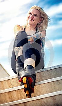 Smiling woman with tattoos and roller blades