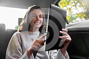 smiling woman in taxi car using tablet pc computer