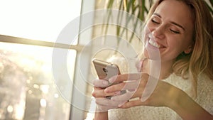 Smiling woman texting sms on smartphone. Joyful woman texting mobile