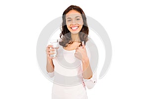 Smiling woman with thumbs up holding glass of water