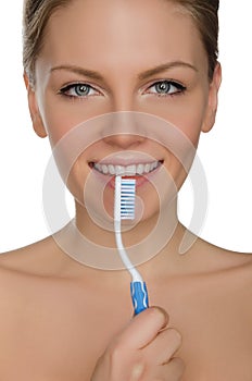 Smiling woman with toothbrush in mouth