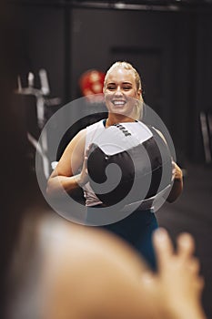 Smiling woman tossing a medicine ball with a gym partner