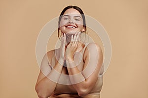 Smiling Woman Touching Face. Woman Smiling While Applying Moisturiser