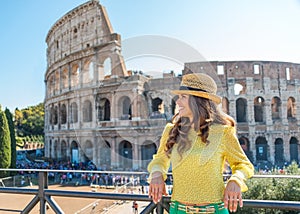 Smiling woman tourist relaxing near Colosseum in Rome in summer