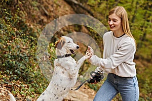 Smiling woman training her pet dog