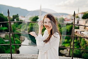 Smiling woman traveller travelling to Southeastern Europe. Visiting local tourist destinations,Old Bridge landmark in Mostar,