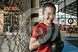 smiling woman ultimate fighter in boxing gloves standing